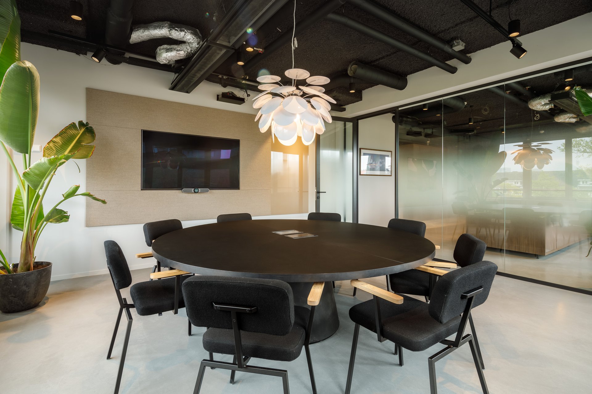 Interior design showcasing a collaborative workspace with ample daylight and bold column structure