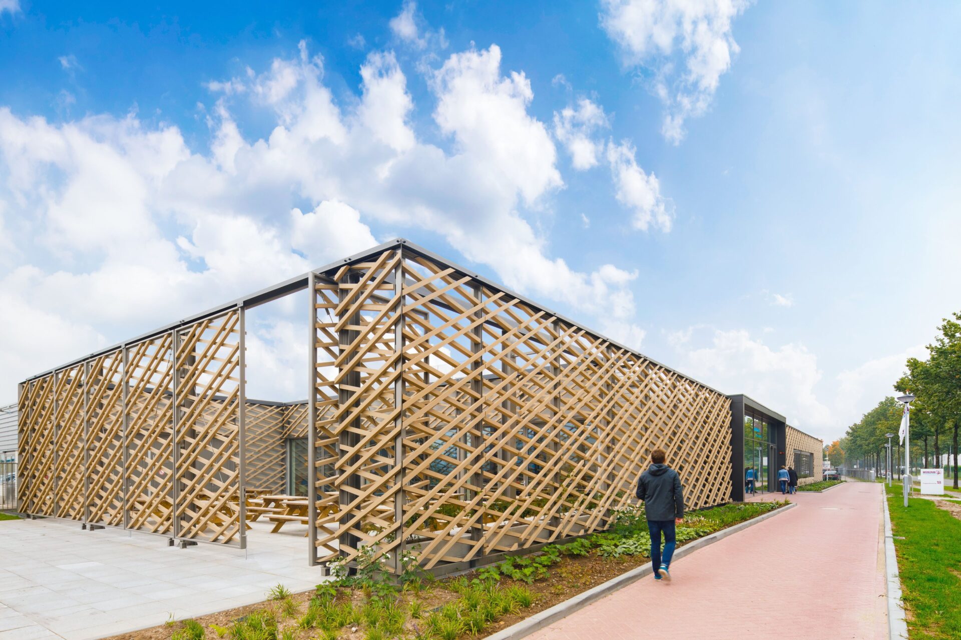 A timber façade wraps itself around the new build extension of the workshop