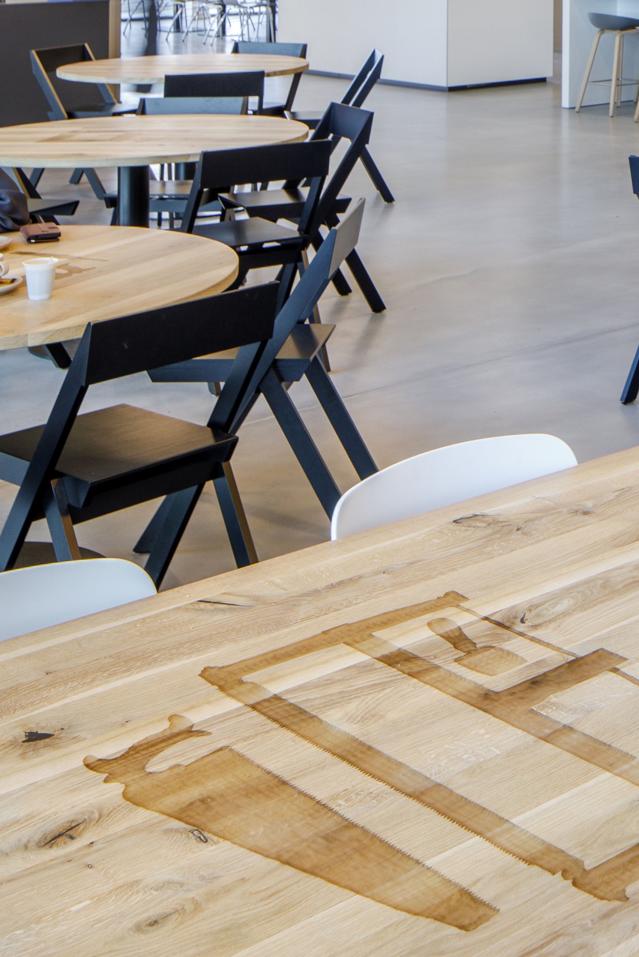 Images of tools are carved into the restaurant tables